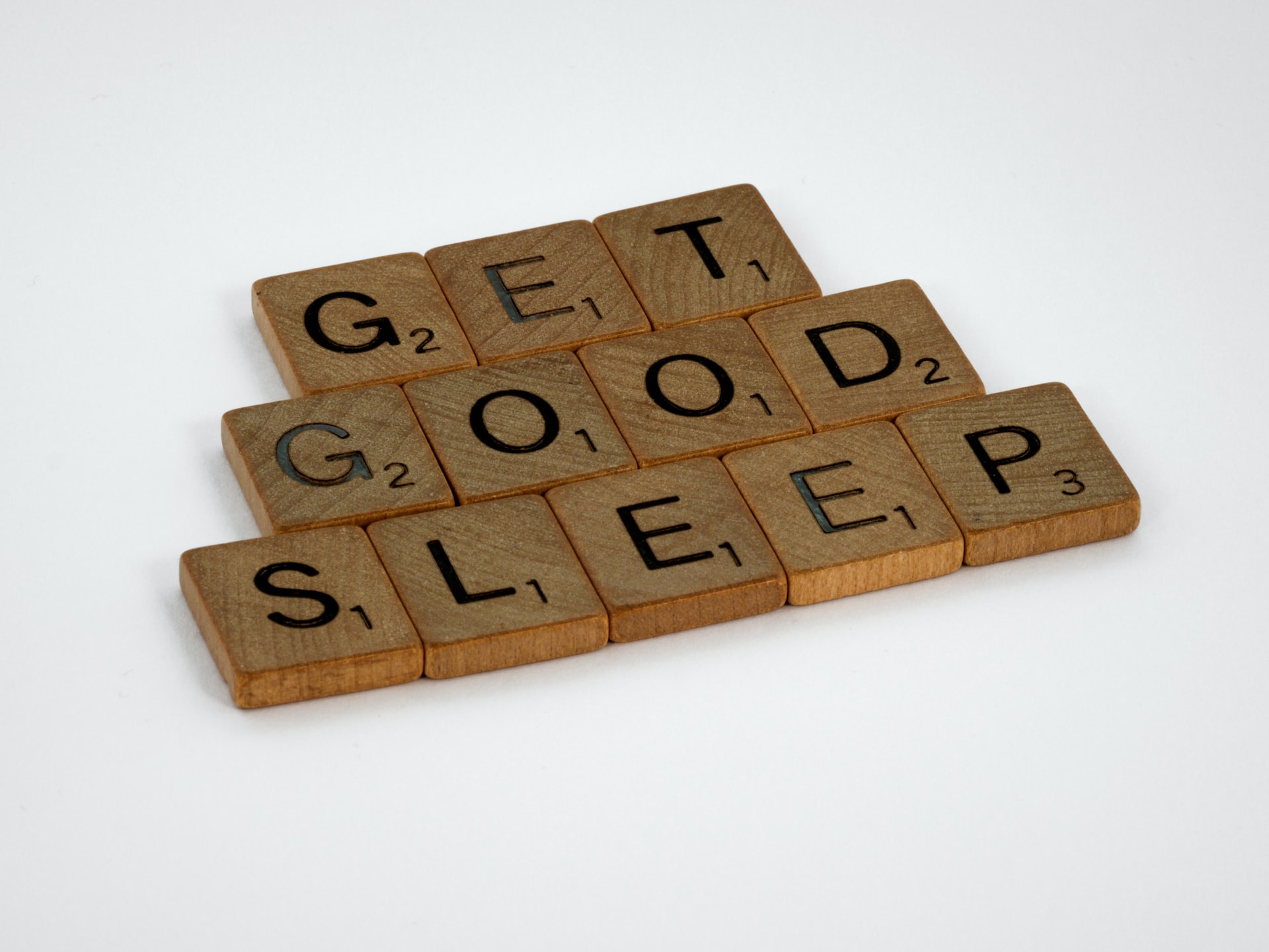 brown wooden letter blocks on white surface